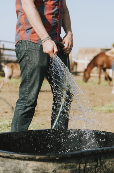 Farmer filling a tub with water